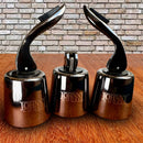 Stopper Hermético para Garrafas de Vinho Johnny Cooker em aço inoxidável prateado com mecanismo da alavanca de pressão, corpo em aço inox e base interna circular de silicone responsável pela vedação.
