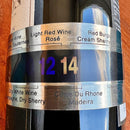 Termômetro para garrafas de vinho estilo colar Johnny Cooker em aço inoxidável. Possui visor de cristal líquido marcando a temperatura em números coloridos, fixado ao redor de uma garrafa de vinho tinto.