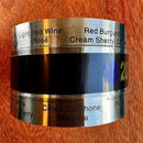 Termômetro para garrafas de vinho estilo colar Johnny Cooker em aço inoxidável. Possui visor de cristal líquido marcando a temperatura em números coloridos, fixado ao redor de uma garrafa de vinho tinto.