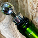 Stoppers metálicos Johnny Cooker nas cores cobre, dourado e prata, exibindo acabamento de alto brilho e anéis de silicone pretos para vedação hermética de garrafas de vinho.