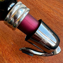 Stopper Hermético para Garrafas de Vinho Johnny Cooker em aço inoxidável prateado com mecanismo da alavanca de pressão, corpo em aço inox e base interna circular de silicone responsável pela vedação.