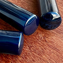 Três facas para queijos da marca Johnny Cooker com lâminas de aço inox polido (modelos lança, cutelo e espátula) e cabos cilíndricos em pedra natural Ágata polidos brilhantes.